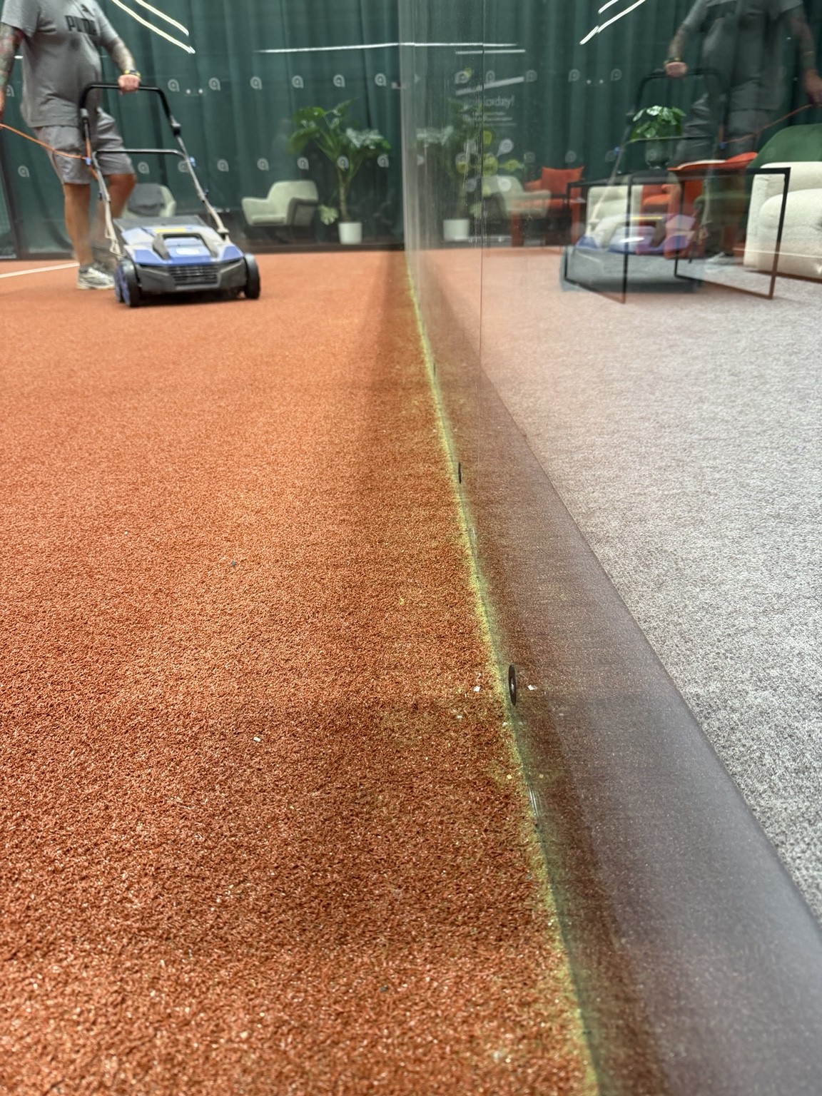 Padel court floor before cleaning with built-up debris along the perimeter